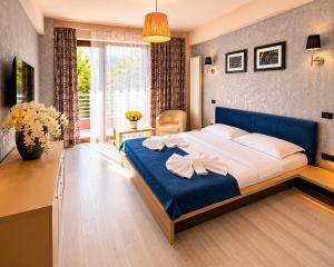 a bedroom with a large bed with a blue headboard at Vila Sangria in Mamaia Sat/Năvodari +98 photos