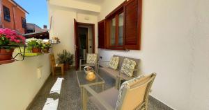a balcony with chairs and a table and a window at The Light House - Olbia centro in Olbia