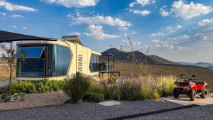 ein winziges Haus mit einem daneben geparkten roten Motorrad in der Unterkunft Capsule Mountain in Lagunillas
