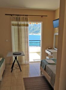 a bedroom with a bed and a desk and a window at Namastekala Holidays Studios in Chrysi Ammoudia