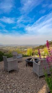 eine Gruppe von Stühlen und eine Feuerstelle auf einer Terrasse in der Unterkunft Capsule Mountain in Lagunillas + 4 Fotos