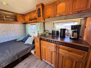 a bedroom with a bed and a kitchen in an rv at Kleine Auszeit in Schermbeck