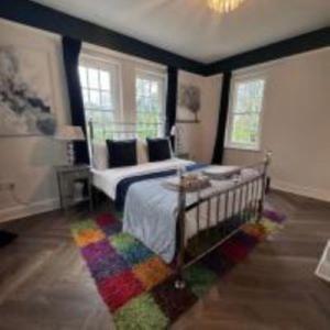 a bedroom with a bed with a rainbow rug at Hilston Gate House in Skenfrith
