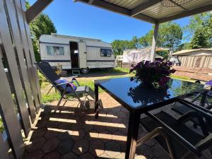 a patio with a table and chairs and a trailer at Kleine Auszeit in Schermbeck
