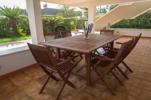 a wooden table and chairs on a patio at Villa Tommi a due passi dal mare in Fontane Bianche