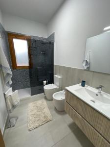 a bathroom with a toilet and a sink and a shower at Villa Tommi a due passi dal mare in Fontane Bianche +24 photos