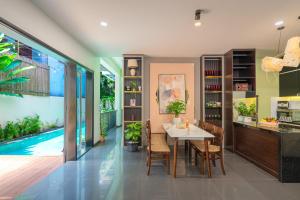 a dining room with a table and a swimming pool at The Coastal Haven pool villa in Hoi An