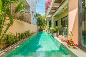 a swimming pool in the middle of a building with plants at The Coastal Haven pool villa in Hoi An