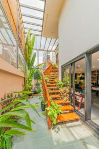 a group of wooden benches in a building with plants at The Coastal Haven pool villa in Hoi An