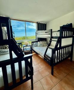 a bedroom with two bunk beds and a large window at Sea View Rooftop in Cabo Rojo +43 photos