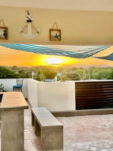 a patio with a table and a view of the sunset at Sea View Rooftop in Cabo Rojo
