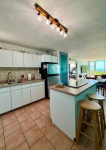 a kitchen with white cabinets and a blue counter top at Sea View Rooftop in Cabo Rojo