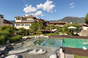 a house with a swimming pool in front of a house at Kreuzwegerhof Nals - Historic Nature Stay with Pool near Meran & Bozen in Nalles