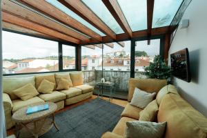 a living room with a couch and some windows at Hotel Casa da Nora in Leiria