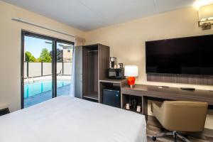 a hotel room with a bed and a desk with a television at Quality Inn in Chatham