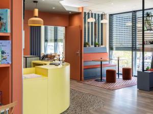 an office with a yellow counter and a desk at Aparthotel Adagio Access Toulouse Jolimont in Toulouse