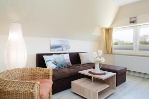 a living room with a brown couch and a table at Villa FarbenFroh in Fehmarn