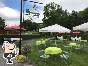 a group of chairs and tables with umbrellas at Altes Posthaus Ahlhorn in Großenkneten
