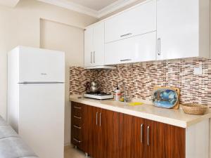 a kitchen with white cabinets and a white refrigerator at Limon Pansiyon Burhaniye in Burhaniye