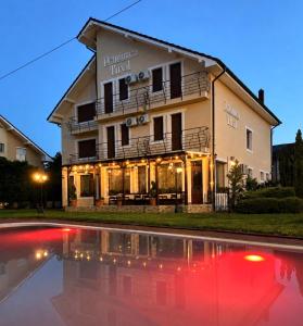 a hotel with a pool in front of a building at Pensiunea Tirol Baile Felix in Baile Felix