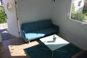 a living room with a blue couch and a table at Strandskatan 102 in Halmstad +3 photos
