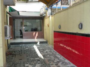 浦那的住宿－Hotel Rajdeep，走廊上设有红色的墙壁和瓷砖地板