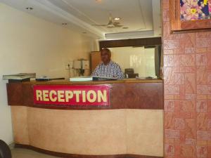 a man is standing behind a reception desk at Hotel Rajdeep in Pune