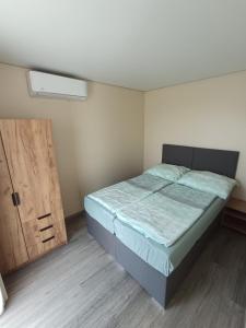 a bedroom with a bed and a wooden door at Bianka & Blanka in Poľný Kesov