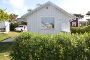 a white house with a window in a yard at Strandskatan 102 in Halmstad