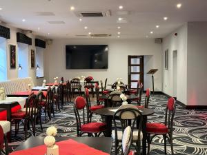 a dining room with tables and red chairs at The Castle Hotel Neath in Neath
