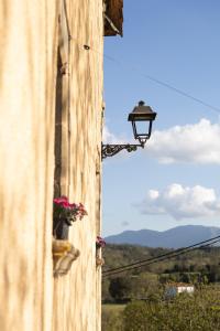une lumière sur le côté d'un bâtiment avec des fleurs à une fenêtre dans l'établissement Mas els Munts, à Vilanova de Sau