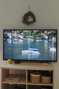a flat screen tv with a boat on the water at Villa Seashell in Prčanj