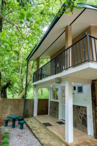 a house with a balcony and a bench at Villa Whispering Leaves Kandy in Galaha Town +31 photos