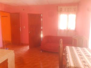 a living room with a red couch and a window at Posada Yacoraite Tilcara in Tilcara