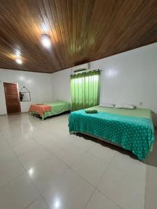 a bedroom with two beds and a window in it at Casa grande perfeita para grupos em Macapá in Macapá