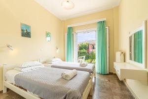 two beds in a room with a window at Katerina Pool Apartments in Acharavi