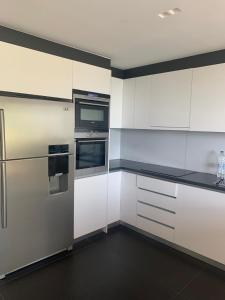 an empty kitchen with white cabinets and appliances at Villa koukla horizon in Agios Nikolaos