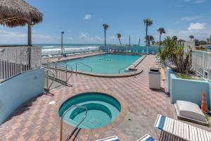 a swimming pool with the beach in the background at Daytona Beach Studio w/ Ocean View + Amenities! in Daytona Beach
