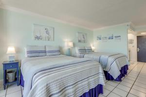 two beds in a room with blue and white sheets at Daytona Beach Studio w/ Ocean View + Amenities! in Daytona Beach +17 photos