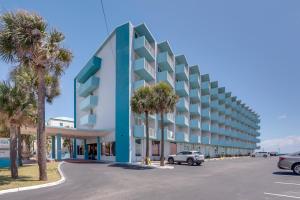 a building with palm trees in a parking lot at Daytona Beach Studio w/ Ocean View + Amenities! in Daytona Beach