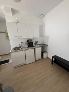 a small kitchen with white cabinets and a sink at Le Saint Vaast - Studio au centre d'Arras in Arras
