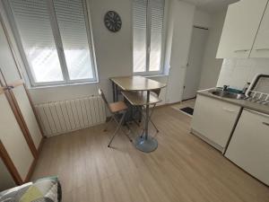 a small kitchen with a table and a sink at Le Saint Vaast - Studio au centre d'Arras in Arras