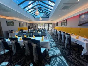 a dining room with tables and chairs and a glass ceiling at The Castle Hotel Neath in Neath
