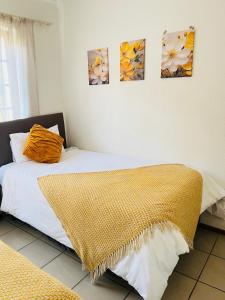 a bedroom with two beds and paintings on the wall at Intsika apartments in Nelspruit +38 photos