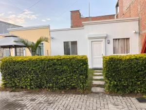 a white house with bushes in front of it at Casa Shelter in Chimbote