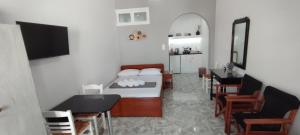 a bedroom with a bed and a table and chairs at Saris rooms in Pera Gyalos