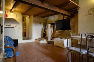 a living room with a television and a table and chairs at Loft in cisterna romana in Amelia