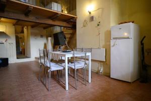 a kitchen with a table and chairs and a refrigerator at Loft in cisterna romana in Amelia