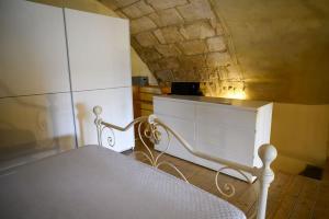 a bedroom with a white bed and a white cabinet at Loft in cisterna romana in Amelia