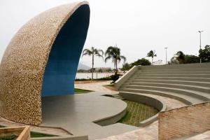 a set of stairs with a sculpture and palm trees at Studio 187 in Rio das Ostras